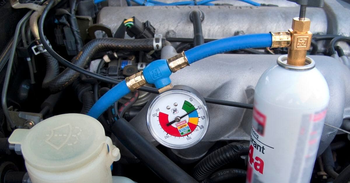 Close-up of AC recharge hose and pressure gauge on car