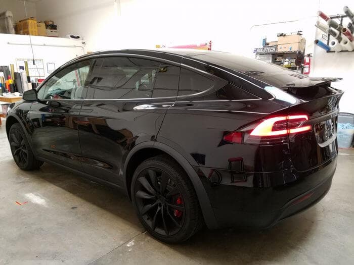 Black electric SUV parked in a garage after a chrome delete treatment