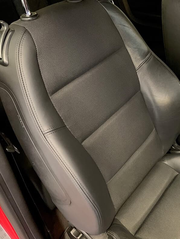 Black leather seat cushion with repaired seam and renewed surface