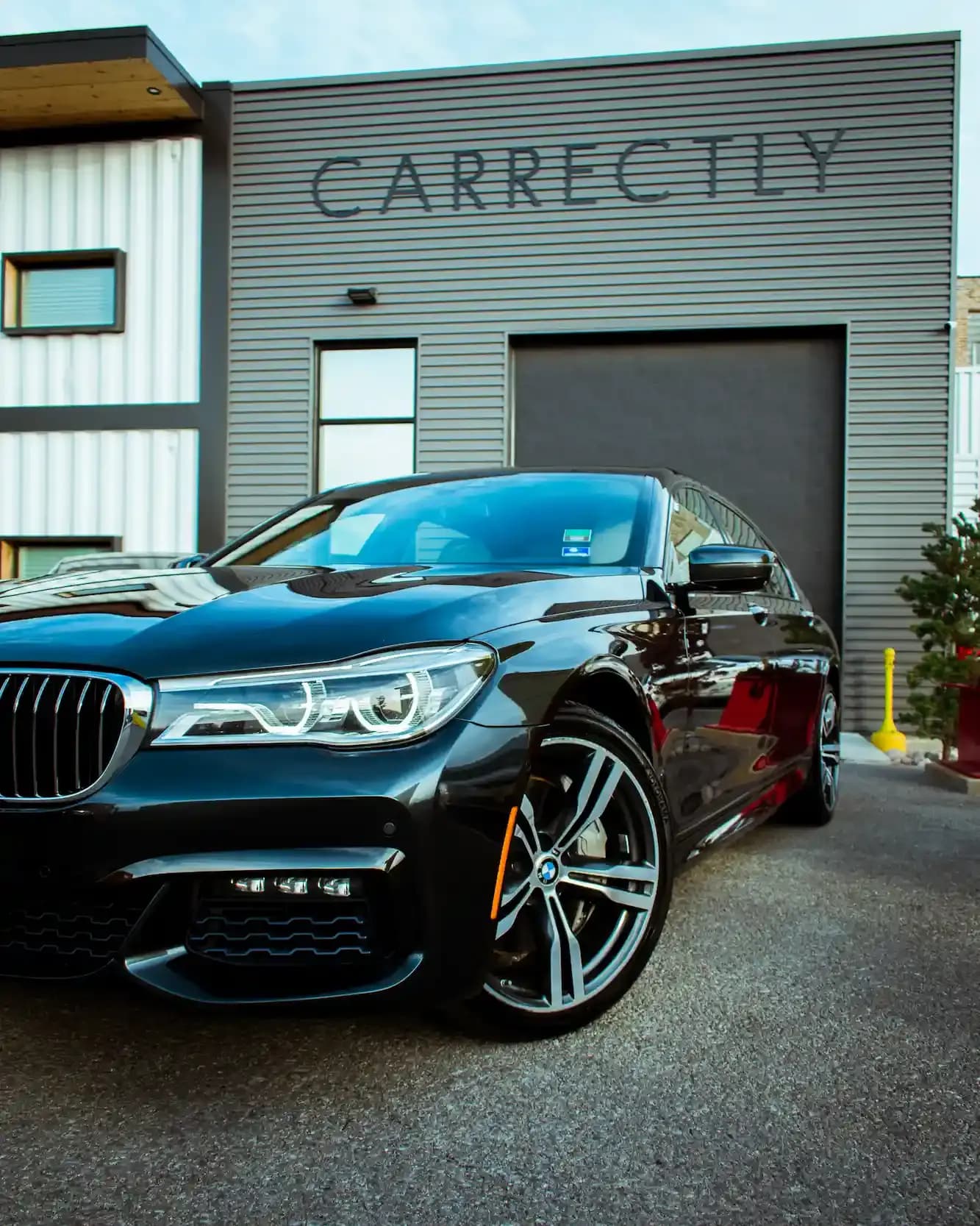 Black luxury sedan parked outside, showcasing a 3-year ceramic coating shine